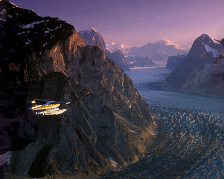 An aircraft flies over a stunning mountain